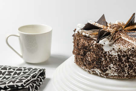 close up view on sweet cake with a cup of tea or coffee and kitchen towel on a light background.の写真素材