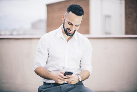 Attractive man and beard with mobile phone.の写真素材