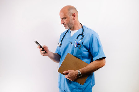 A doctor wearing a light blue lab coat and using a smartphone.