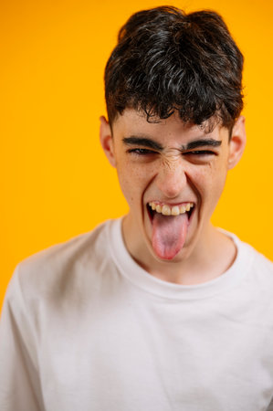 Teen boy sticking out tongue, playful, defiant expression.の写真素材