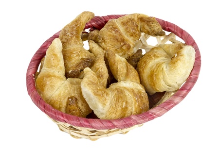 Buns, croissants, bread sticks in a wicker basket isolated on white background の写真素材