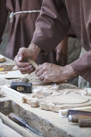 Traditional craftsman carving wood with floral motifsの写真素材