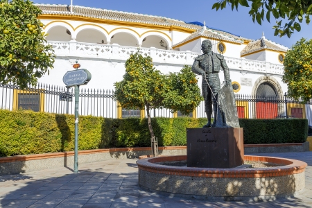 The Bullring ,Plaza de toros de la Real Maestranza de Caballeria de Sevilla, with matador statue in the foreground, Seville, Seville Province, Andalusia, Spainの写真素材