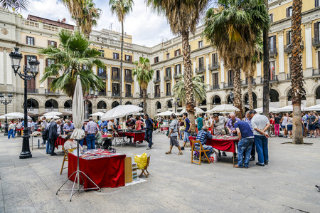 BARCELONA - JUNE 29, 2014: Tourists on Plaza Real in Barcelona, Spain. The Royal Plaza is a square in the Gothic Quarter. Located next to La Rambla and is a well-known tourist attraction. All holidays, collectors gather to buy stamps and coin collection.のeditorial素材