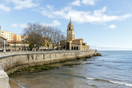 Gijon , Spain - March 31, 2015: Looking along San Lorenzo's beach towards the peninsula of Santa Catalina, San Pedro church  at Gijon in Asturias, Spain.のeditorial素材