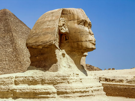 Sculpture of the Great Sphinx against the blue sky. Profile view. The head, part of the body and the...