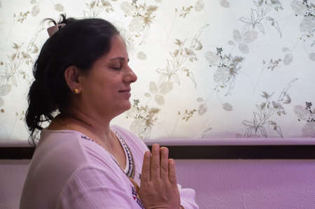 Indore, India - June 9,'2020: Indian/asian woman praying at home in coronavirus lockdown.のeditorial素材