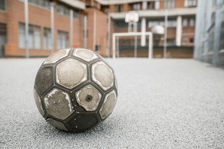 Old worn leather ball  on a playgroundの写真素材