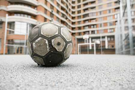 Old worn leather ball  on a playgroundの写真素材