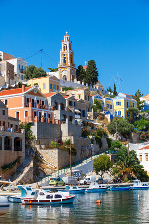 SYMI, GREECE - JUNE 12,2015: View of a coastline street and fishing boats moored in Yialos harbour on June 12, 2015 on Symi island, Greece. Symi is easy and most popular destination for day tripping from Rhodes island.のeditorial素材
