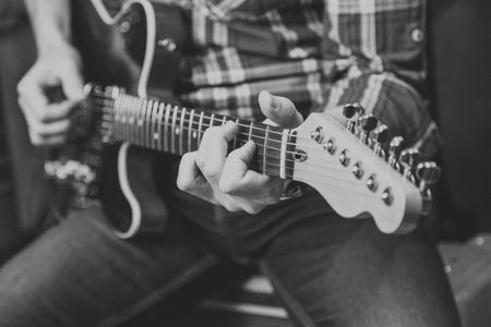 Close up view of man's hands playing electric guitar.の写真素材