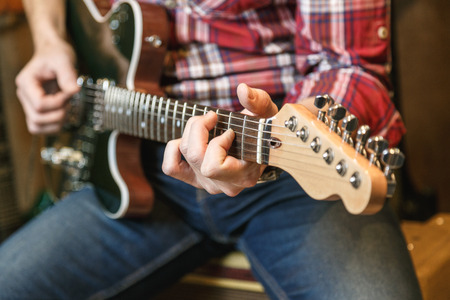 Close up view of man's hands playing electric guitar.の写真素材