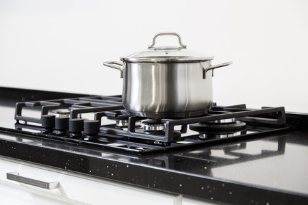 New iron pot on a black gas stove on a kitchenの写真素材
