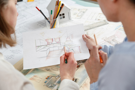 Interior designers working on color hand drawings of a kitchen interior at work place. Photo of young designers work conceptの写真素材