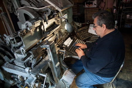 MEXICO CITY,MEXICO - March 3,2012 : Owner of typography business with still popular linotype machine...