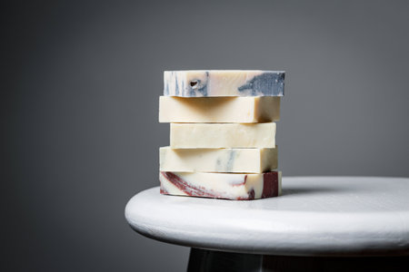 Natural handmade soap bars with different ingredients on a white wooden background. Organic skin care treatment conceptの写真素材