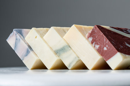 Natural handmade soap bars with different ingredients on a white wooden background. Organic skin care treatment conceptの写真素材