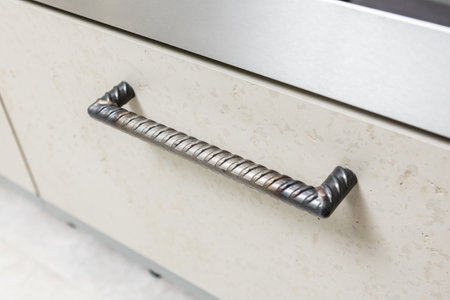 Metal welded door handles used with artificial stone facade in kitchen furniture facades. Modern interior furniture making conceptの写真素材