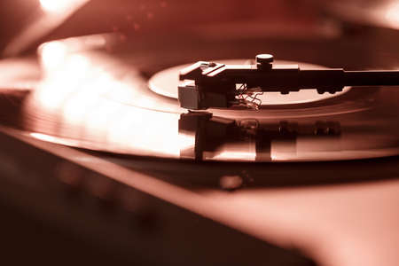 Closeup view of a tonearm and turntable playing vinyl record. Entertainment and music trendsの写真素材