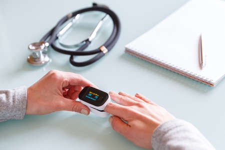 Female patient hand measuring oxygen saturation and pulse using portable oximeter. Health care conceptの写真素材