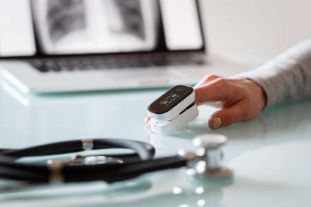 Female patient hand measuring oxygen saturation and pulse using portable oximeter. Health care conceptの写真素材