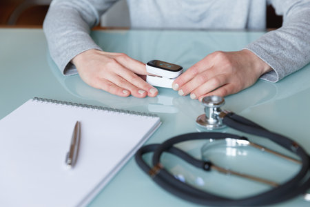 Female patient hand measuring oxygen saturation and pulse using portable oximeter. Health care conceptの写真素材