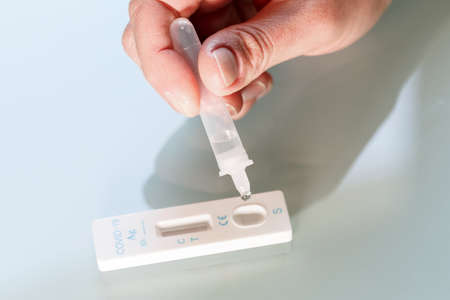 Drop of a test material in a rapid test cassettee  for covid-19 antigen test. Medical care concept