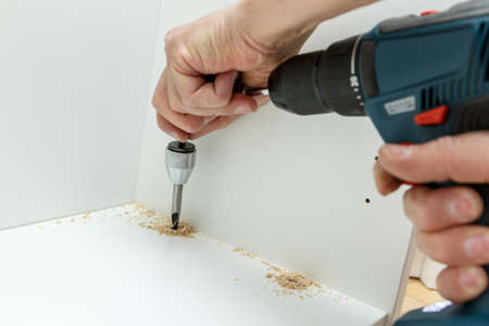 Carpenter using angle drilling bit adapter in furniture making process. Carpentry and woodworking instrumentsの写真素材