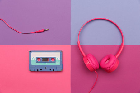 A-side of blue  audio cassette and pink headphones on a color paper  background. Analog audio music conceptの写真素材