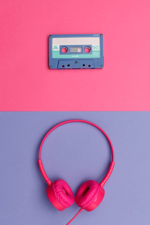 A-side of blue  audio cassette on a pink background and pink headphones on a violet  background. Analog audio music conceptの写真素材