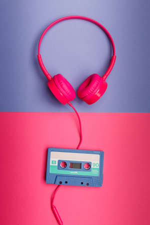 B-side of blue  audio cassette on a pink background and pink headphones on a violet  background. Analog audio music conceptの写真素材
