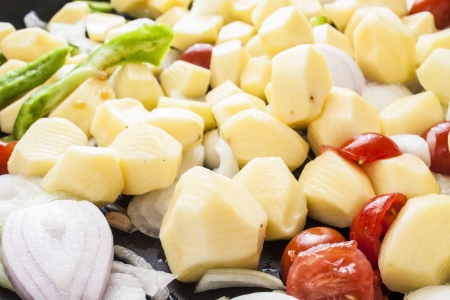 tomatoes onions and peppers cut, ready for roastingの写真素材