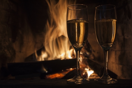 glasses of champagne in front of fireplaceの写真素材
