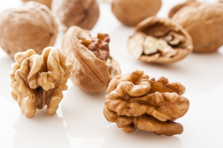 walnut and a cracked walnut on white backgroundの写真素材