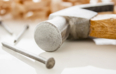 hammer and nails on a wood board with sawdust shavingsの写真素材