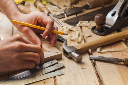carpenter working,hammer,meter and screw-driver on construction background