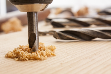 drilled hole with saw dust on wood tableの写真素材