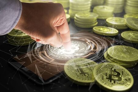 Cryptocurrency and future technology concept - close up of hands with bitcoin symbol hologram on smartphone screenの写真素材