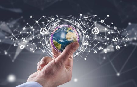 Businessman holding globe with social media network icons structureの写真素材