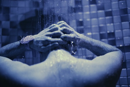 man take a shower in a blue bathroomの写真素材