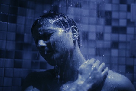 man take a shower in a blue bathroomの写真素材