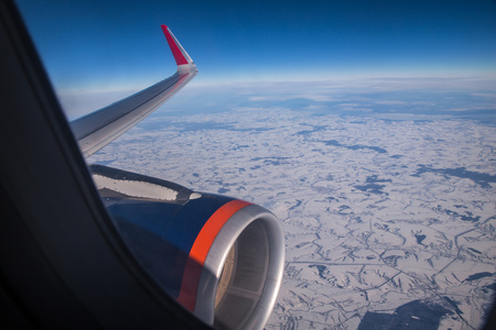 sky through aircraft window onto jet engineの写真素材
