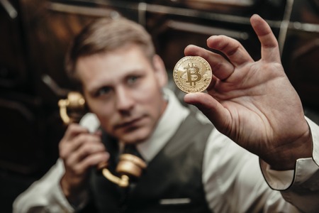 the younge man holding the bitcoin in the handの写真素材