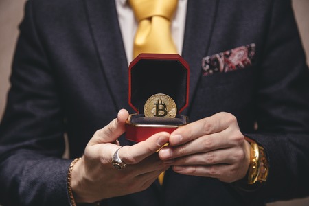 a man holds an enlarged box with bitcoinの写真素材