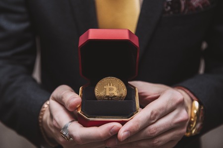 a man holds an enlarged box with bitcoin