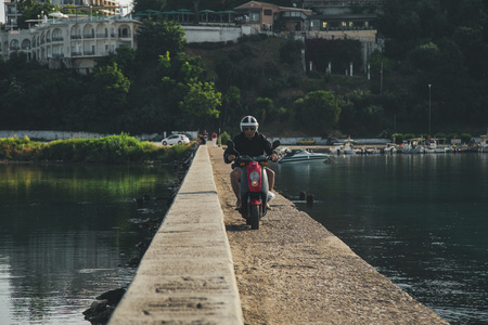 Corfu, Greece, 6 June 201, an elderly man is riding a motorbike on the bridgeのeditorial素材
