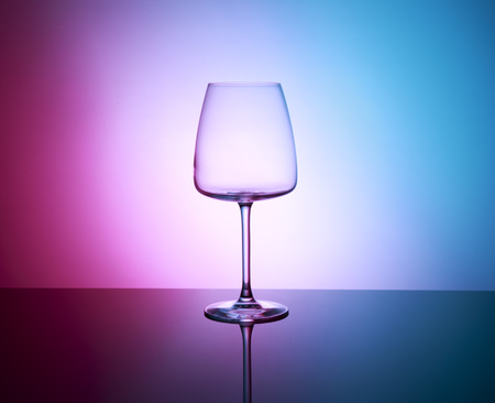 Glass of water with color  on the mirror table isolatedの写真素材