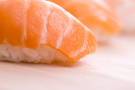 Set of sushi on a wooden board with leaves of plants on a darkの写真素材