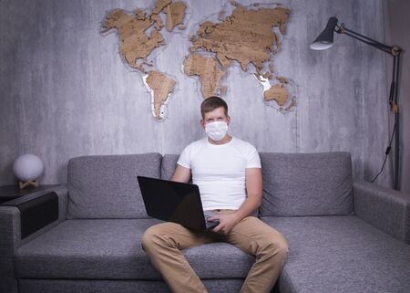 man in quarantine for Coronavirus wearing protective medical mask and smart working at homeの写真素材