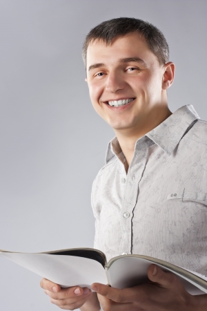 Young man reading a book, isolated on greyの写真素材